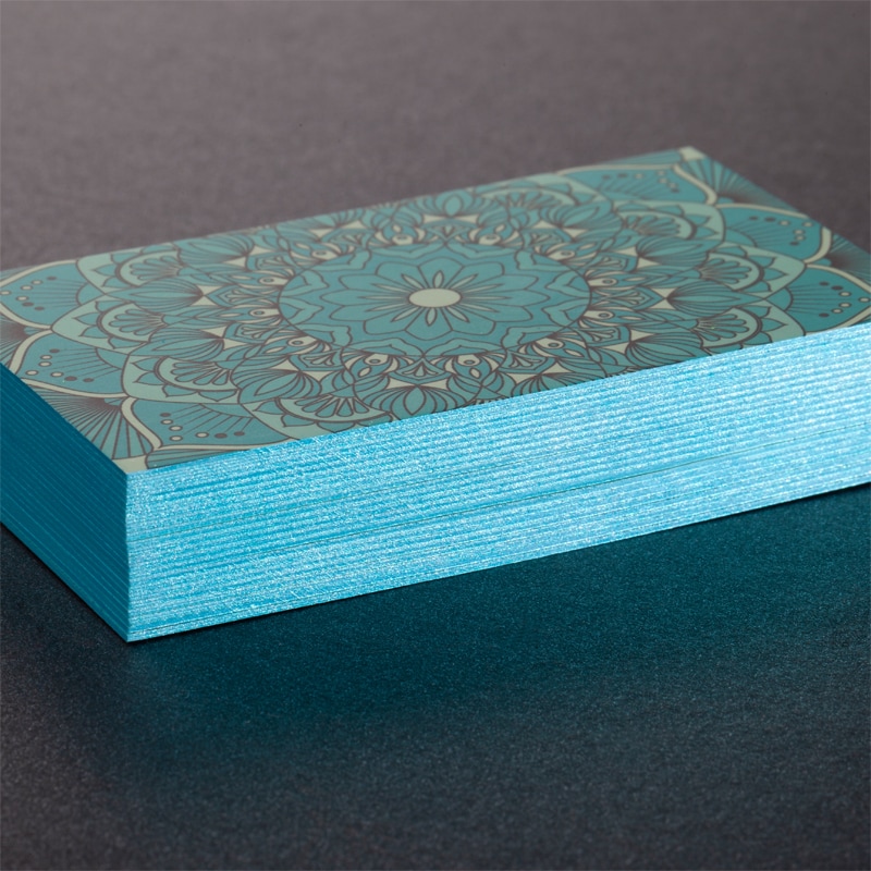 Thick business cards after the painted edges process, with turquoise metallic edges