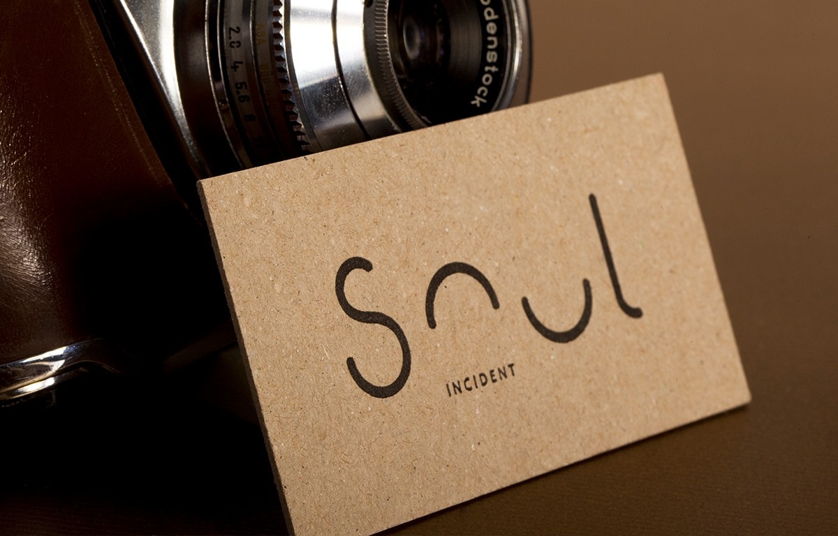 Single recycled paperboard business card showing a lightly flecked surface