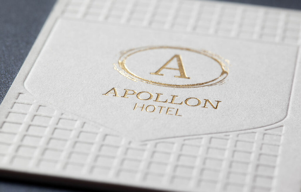 Close detail of gold hot foil and blind geometric impression on the white Sumo house sample