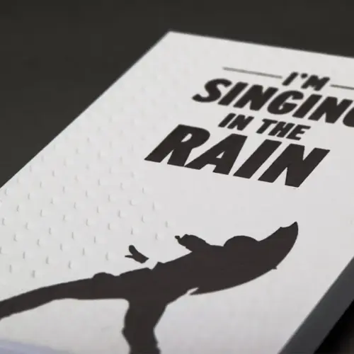 Business cards showing a man singing in the rain.