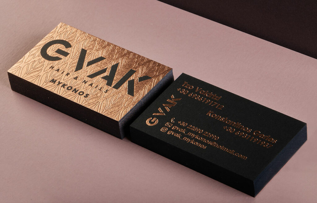 Front and reverse of GVAK business cards with rose-gold foil on black board