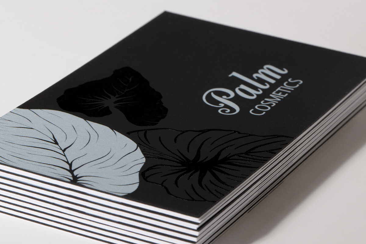 Raised gloss following black leaf shapes on a matt black Plike business card