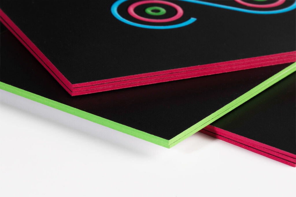 Anagram card stacks with bright pink and green painted edges
