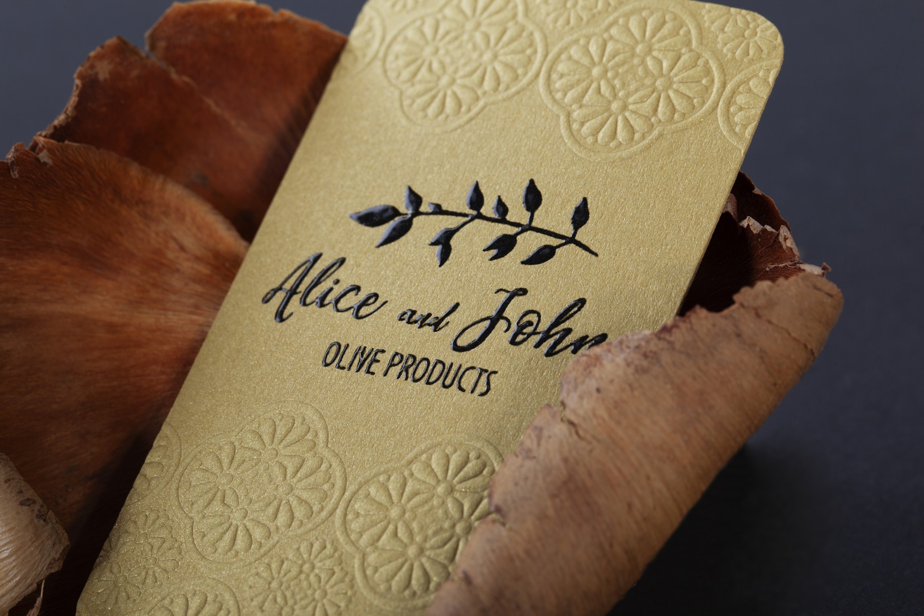 Curious Metallics Olive business card held to show its pearlescent surface