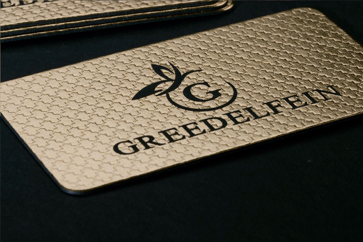 Stack of textured gold business cards with rounded corners