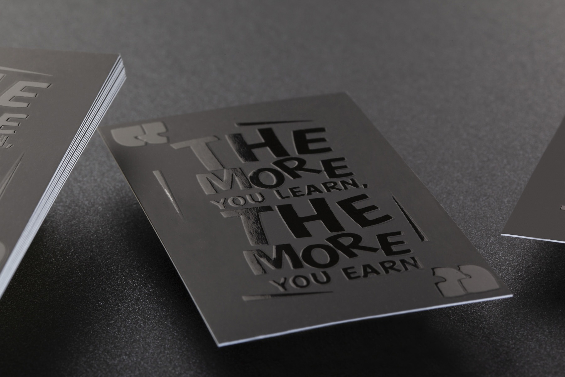 Black business card combining glossy Spot UV and embossed typography