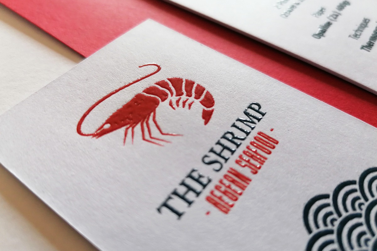 Close view of red raised thermographic lettering on a white business card