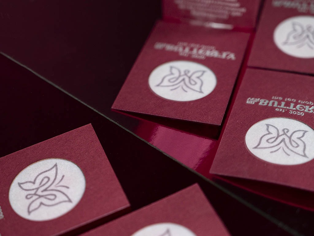 Burgundy triplex business cards showing pale printed centres