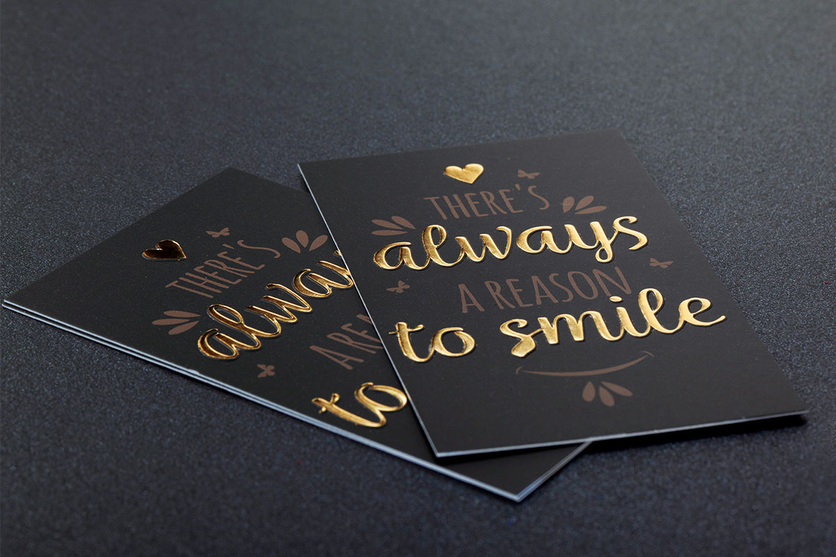 Stack of black velvet-finish cards with gold foil and full-colour printing